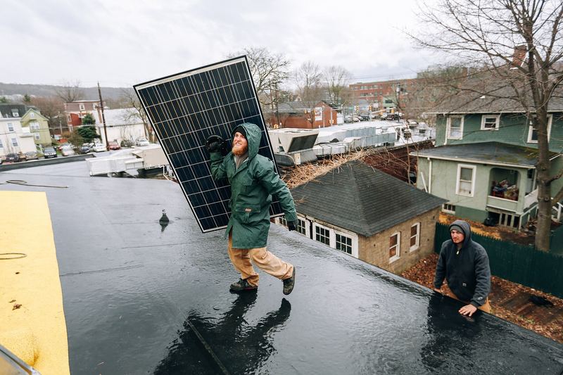 Solar installers working on a rooftop photovoltaic array